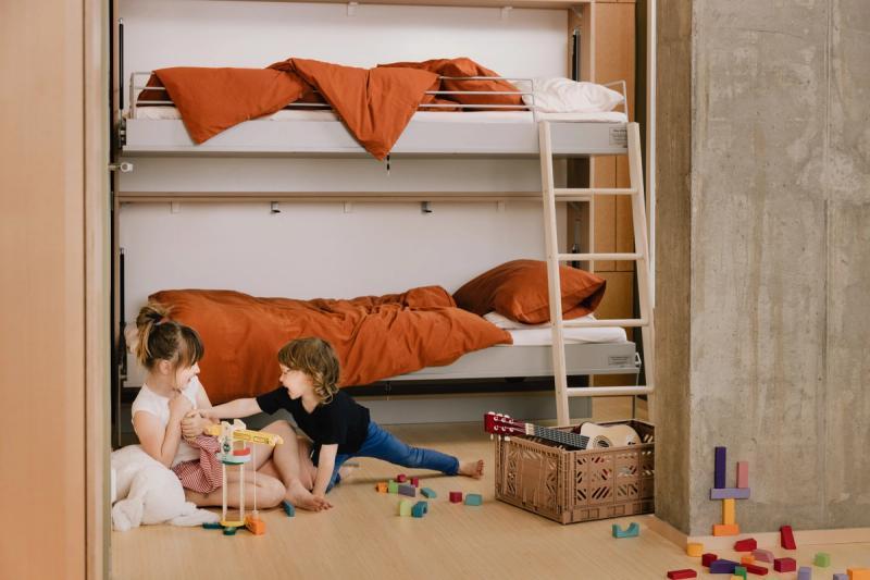 To barn som leker på soveromsgulvet i OBOS Living Lab.